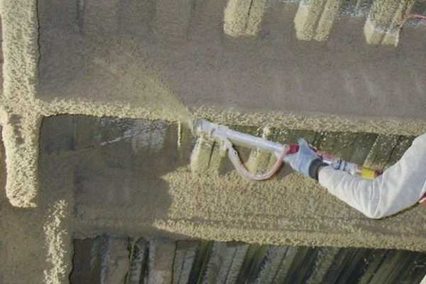 Man doing fire proofing insulation to a commercial building